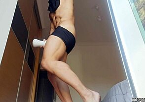 A girl stands naked in the window, while being fucked hard with a Fleshlight